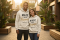 Lady and gentleman wearing the beige Made For A Purpose hoodie outdoors